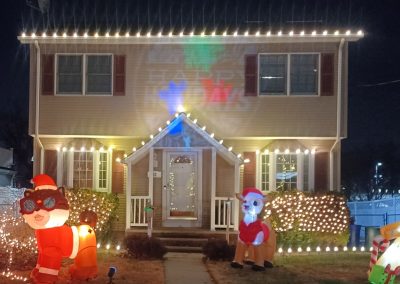 christmas lights on a residential property cream exterior with red shutters and Christmas decorations, from our gallery