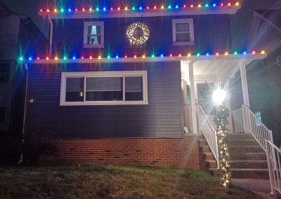 residential home at night with colorful Christmas lights,