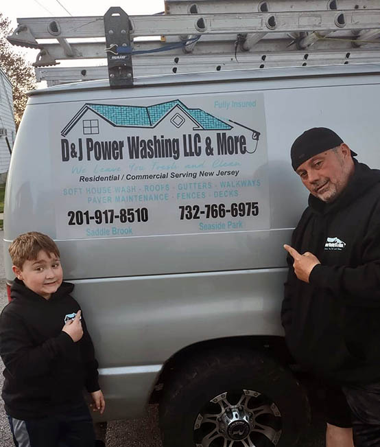 man and boy pointing to the DJ Power Washing van to contact us today